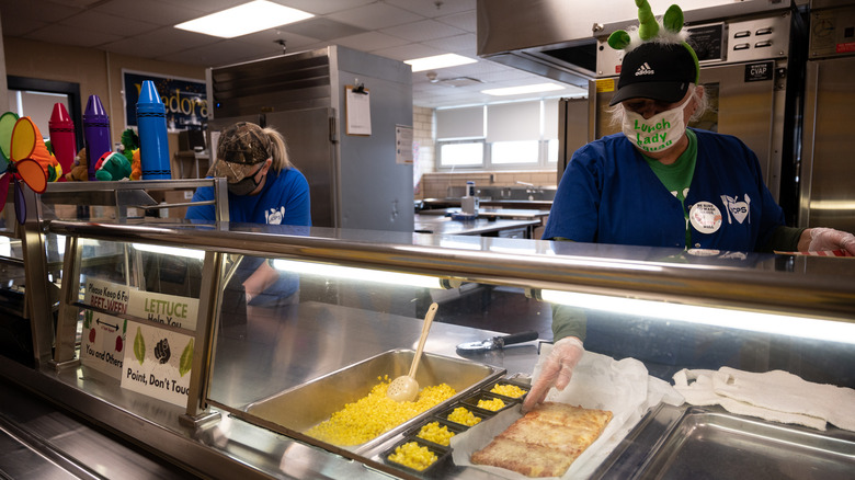 Employees prepare the school lunch