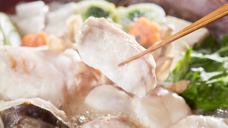 cooked fugu held by chopsticks