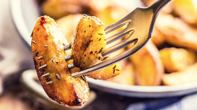 roasted potato wedges on fork