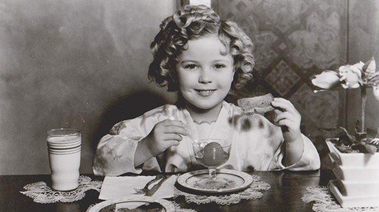 Shirley Temple eating at table 