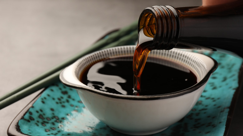 Pouring soy sauce into a small dish