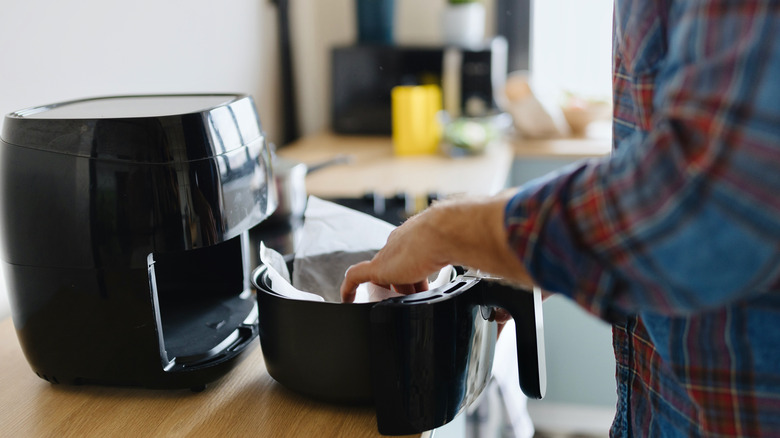 Hand preparing air fryer