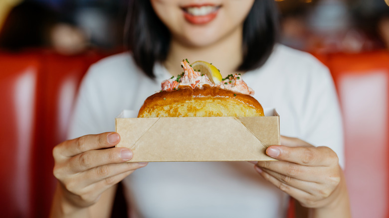 person holding lobster roll