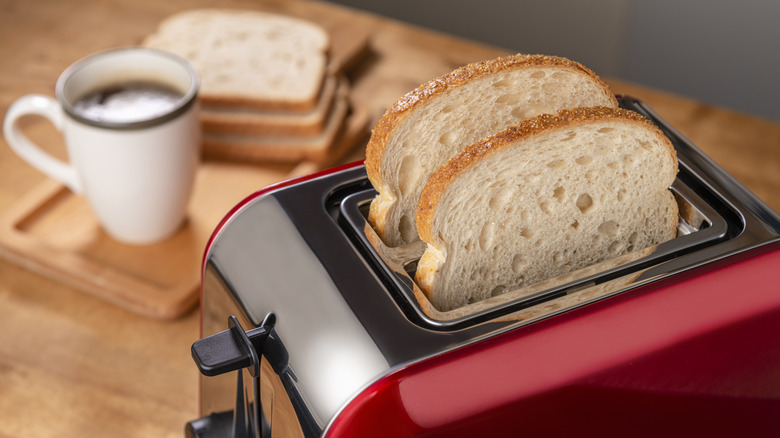 Thin bread slices in red toaster