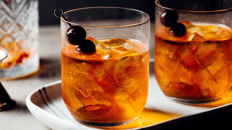 two bourbon cocktails with cherry garnishes