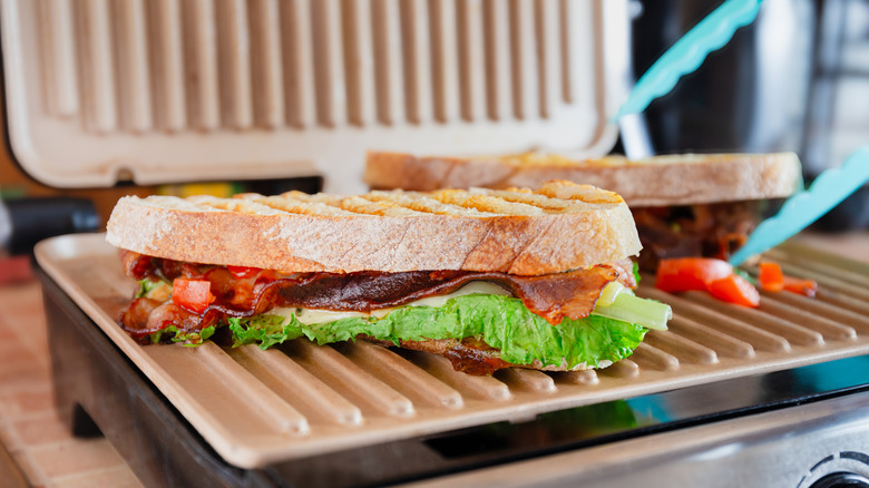 Open panini press with an Italian sandwich placed in it