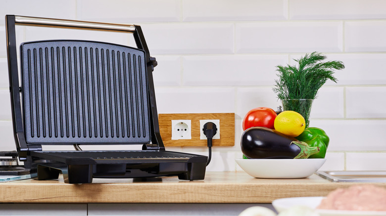 Open panini press on a kitchen counter