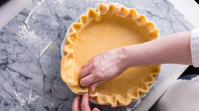 putting pie crust into a dish