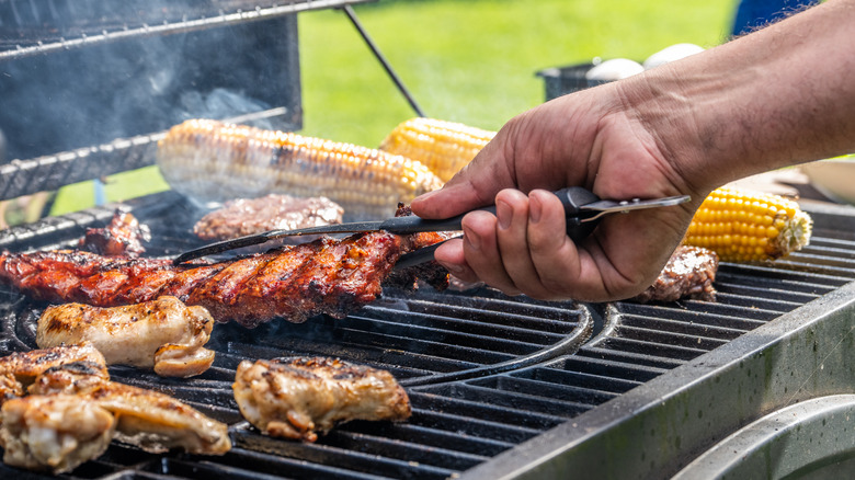 tongs lifting barbecued meats