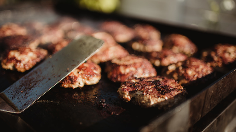 burgers cooking on flat griddle