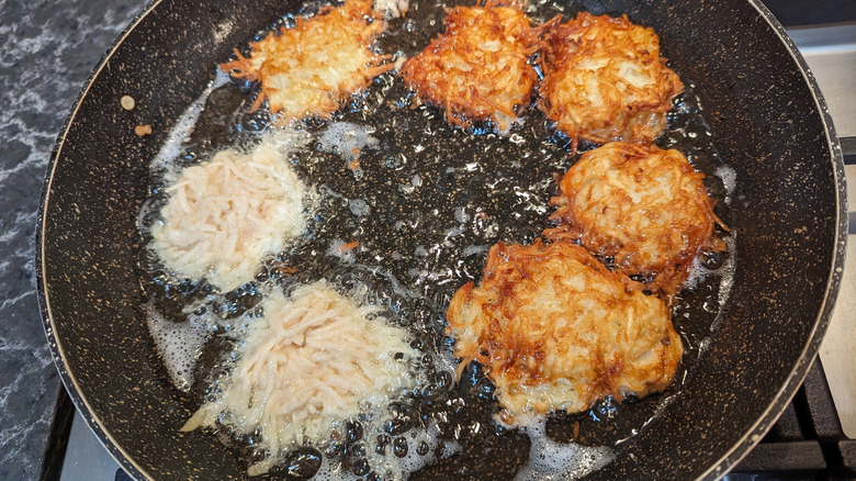 A sizzling pan of frying latkes