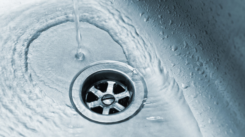 Close up of kitchen sink drain with running water