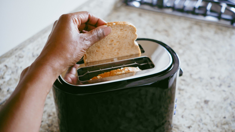 putting toast in a toaster