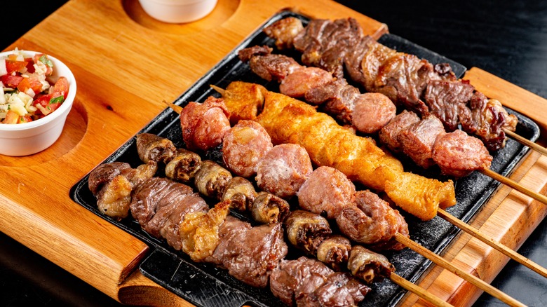 different cuts of meat skewers on wooden table