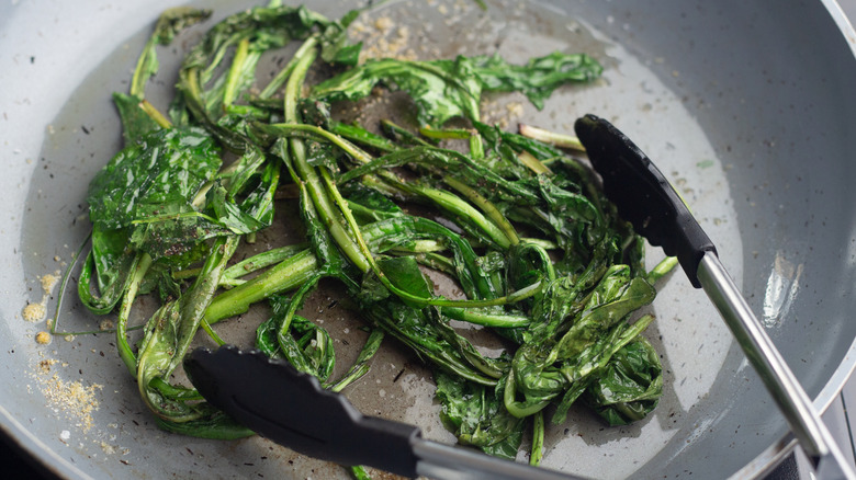 sauteing dandelion greens in a skillet