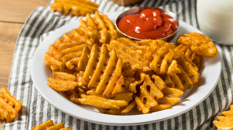 plate of waffle fries with ketchup