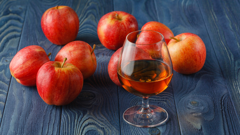 Glass of Calvados with red apples