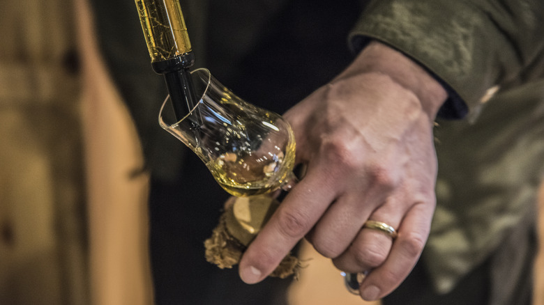 Hand pouring glass of Calvados