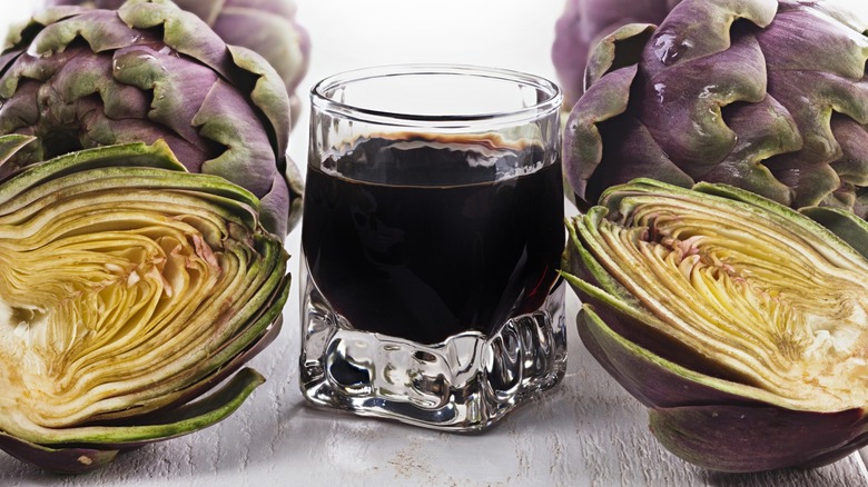 A glass of Cynar liqueur with artichokes