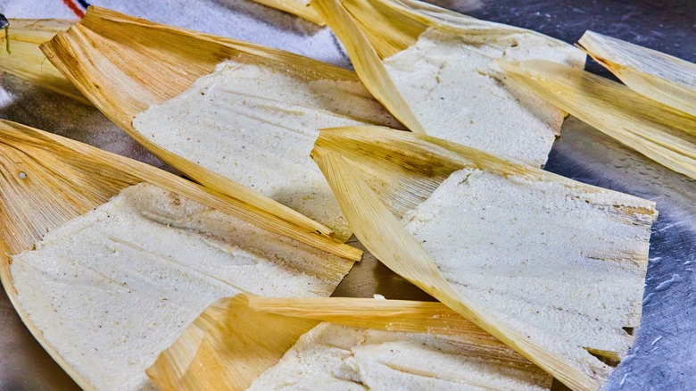 filled corn husks on a baking tray