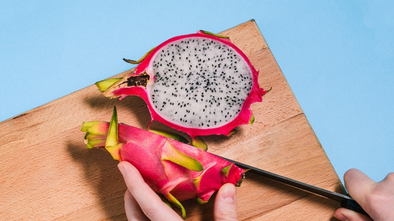 person cutting dragon fruit