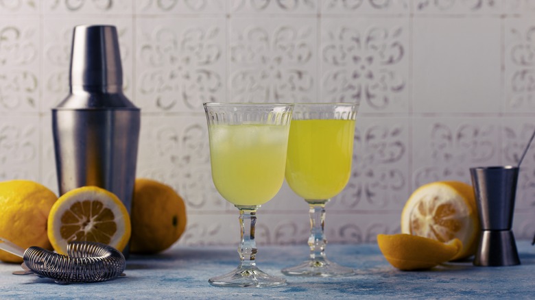 Glasses of limoncello with lemons and shaker
