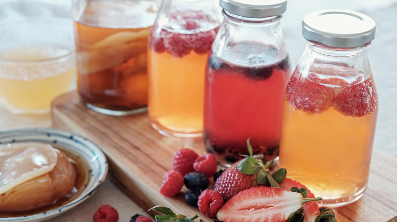 Bottles of homemade kombucha with different fruits