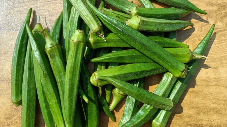 Whole okra on wooden table 