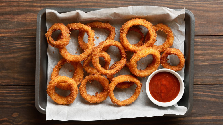 baked onion rings on a lined oven dish