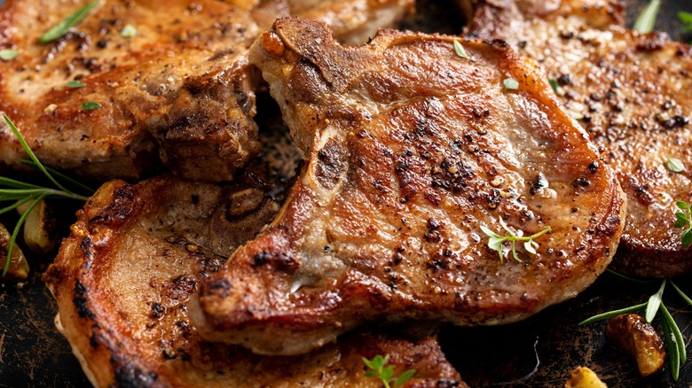 Close-up of seared pork chops with herbs and pepper