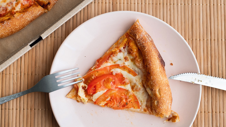 A slice of pizza on a white plate