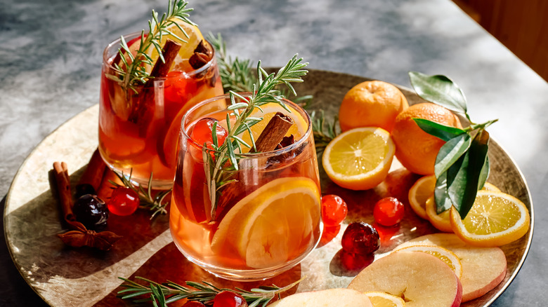 fall sangria with fruits, herbs, and cinnamon sticks