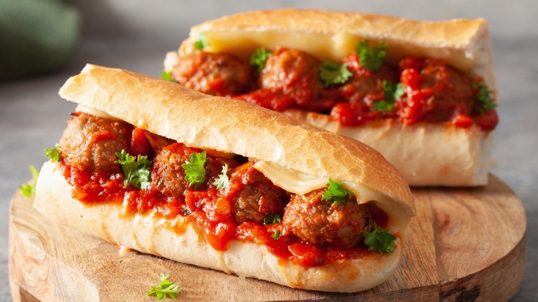 Sliced meatball marinara sandwich on wooden board