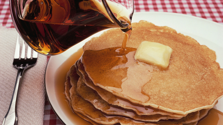 pouring syrup onto pancakes