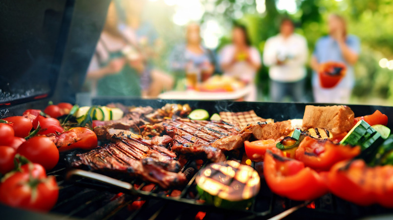 meat and vegetables on grill at cookout