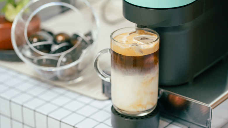 Nespresso machine brewing iced coffee in a home kitchen