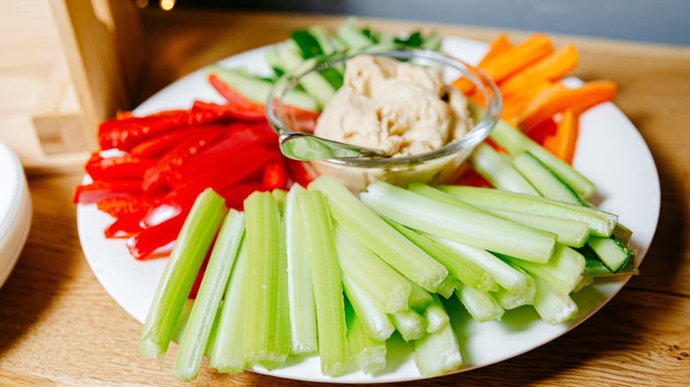 Peppers, celery, and carrots on a plate with dip