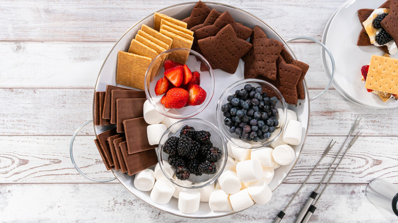 S'mores charcuterie board with fruit, marshmallows, and graham crackers