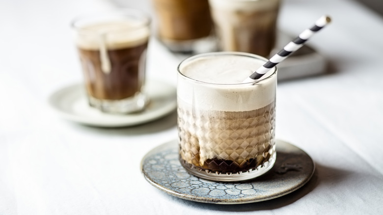 Iced coffee with foam and straw