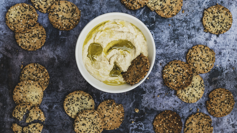 crackers surrounding creamy hummus