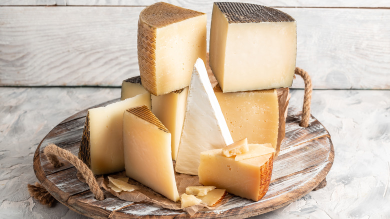 different types of cheeses stacked on wooden tray