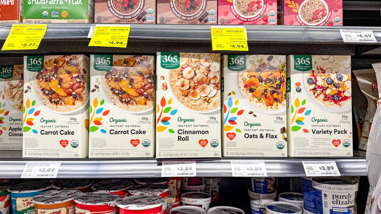 Boxes of 365 organic instant oatmeal are displayed on a grocery store shelf.