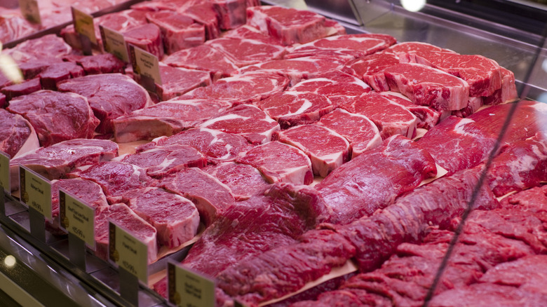 Cuts of meat are seen in a Whole Foods display case.