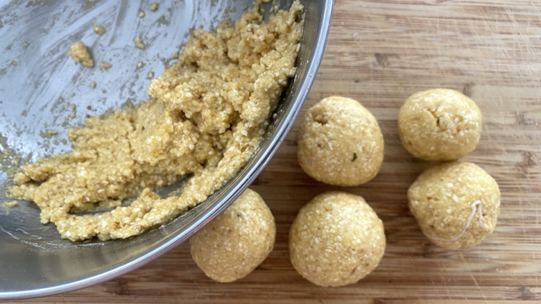 Matzo ball mix in a bowl and a few balls on a cutting board