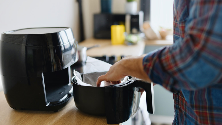 Hands preparing air fryer