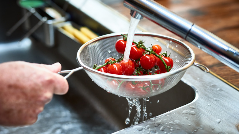 Small tomatoes on the vine rinsed in sieve