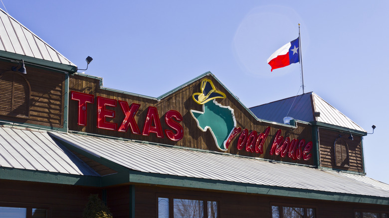 The storefront of a Texas Roadhouse complete with a Texas flag