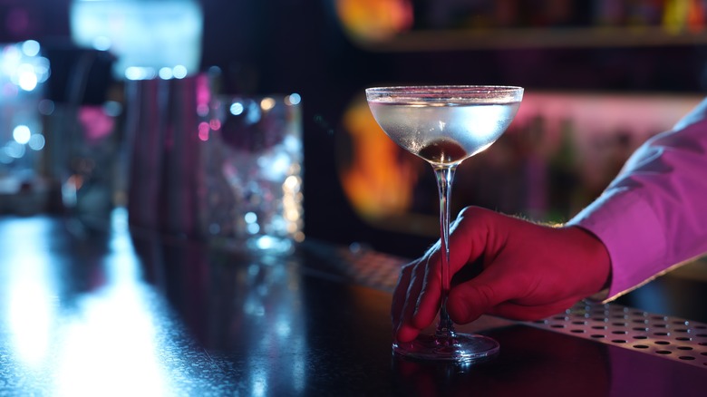 a bartender serves a martini