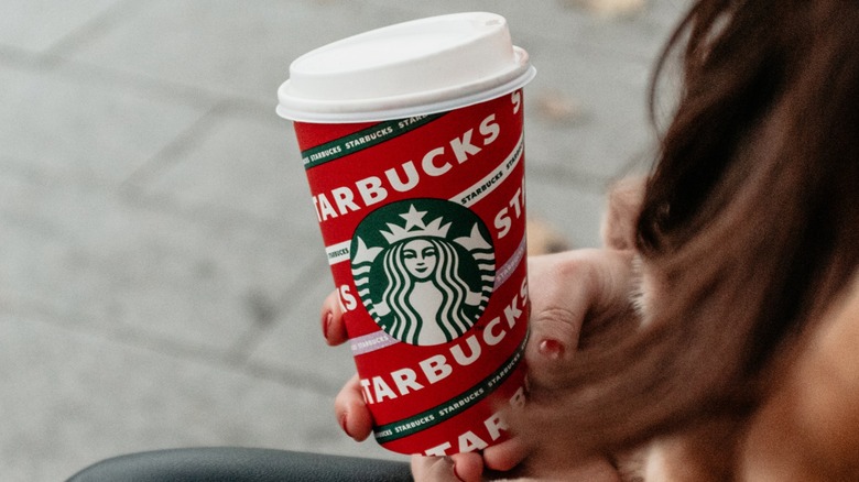 holding Starbucks holiday cup