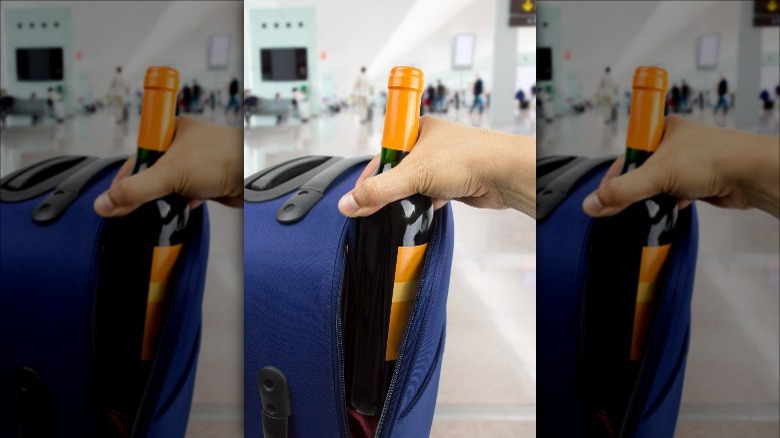 placing wine bottle in suitcase